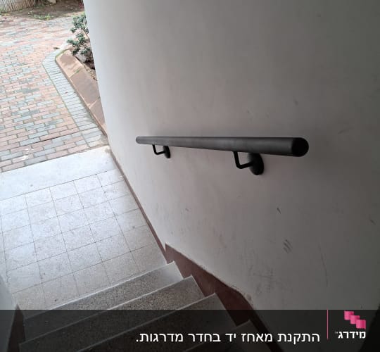 מעקה מתכת מותקן לאורך גרם מדרגות